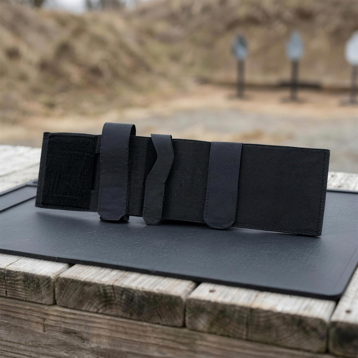 ICONTACTIC Ankle Utility Carrier, concept render pending supplier verification, empty carrier laid flat on an outdoor range bench